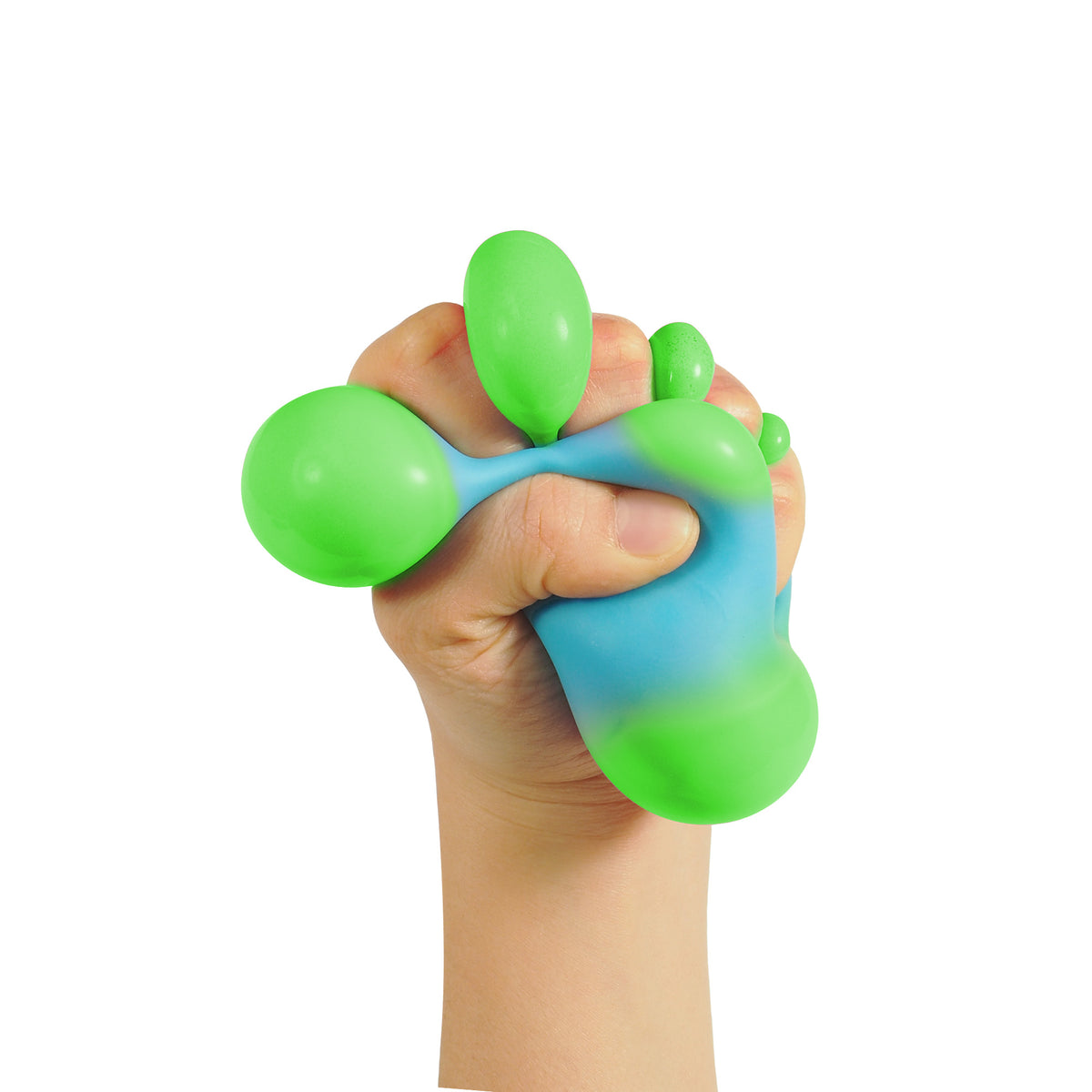 A hand tightly gripping a squishy, bi-colored sensory toy. The toy is primarily green with a blue gradient. The background is plain white, highlighting the texture and colors of the sensory toy.
